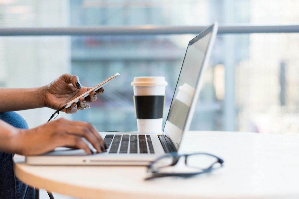 Osoba koristi laptop i mobilni telefon za administraciju WordPress sajta putem WP Toolkit alata u poslovnom okruženju.
