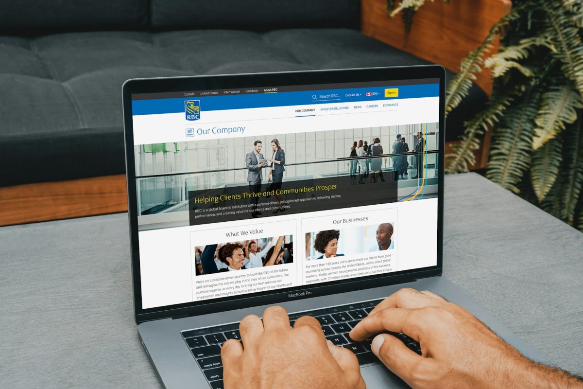 Osoba koristi laptop sa prikazom poslovnog web sajta – ilustracija za hosting i upravljanje online platformama u modernom digitalnom okruženju.