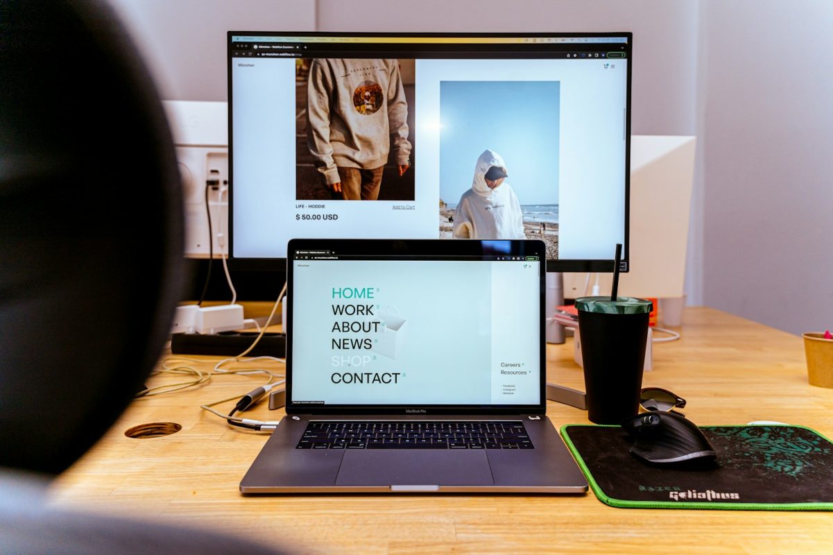 Laptop i monitor sa otvorenim portfolio sajtom u modernom radnom okruženju - prikaz kako web hosting za portfolio omogućava jednostavno predstavljanje radova online.