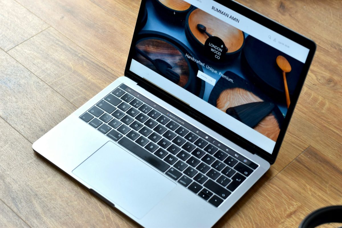Laptop sa otvorenim modernim web sajtom na drvenom stolu – prikaz kako web hosting za agencije u Srbiji omogućava pouzdan rad i prezentaciju projekata klijentima.